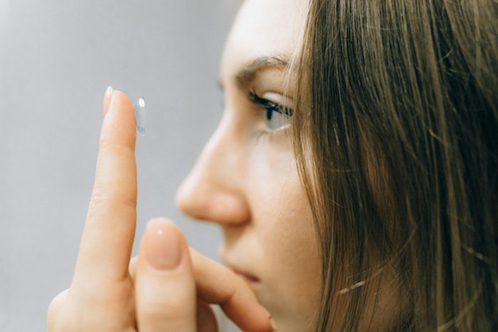 Woman putting a contact lens in her eye